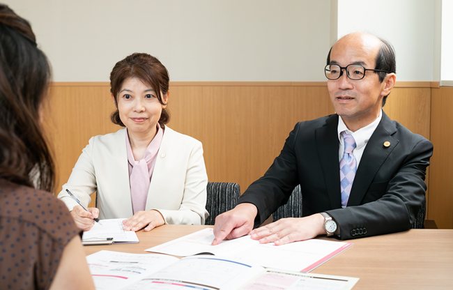 テーブルを囲んで相談を受ける行政書士