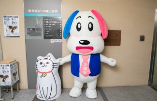 会館の入口で来館者を迎えるさぽ太